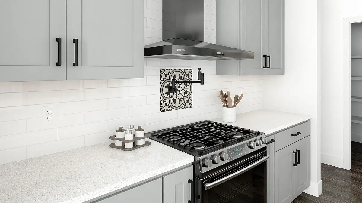 Light gray cabinets around a gas range and chimney hood
